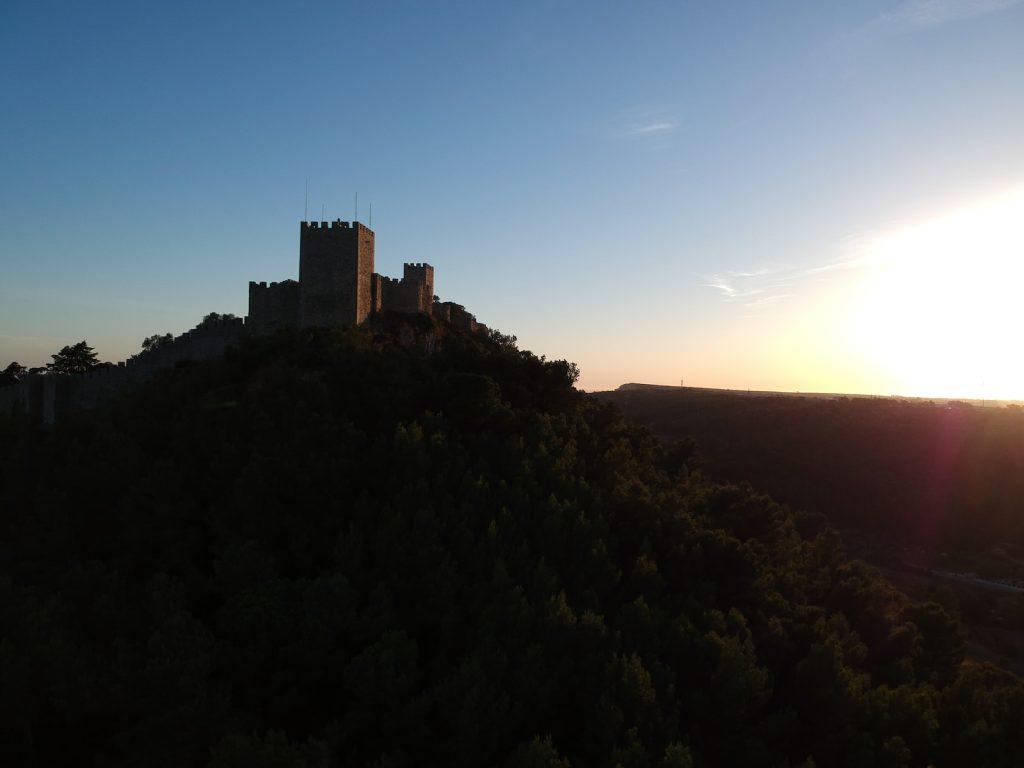 a castle sitting on top of a lush green hillside