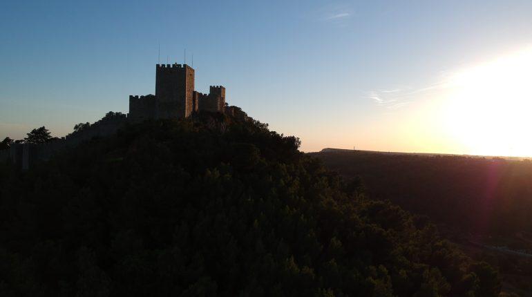 a castle sitting on top of a lush green hillside