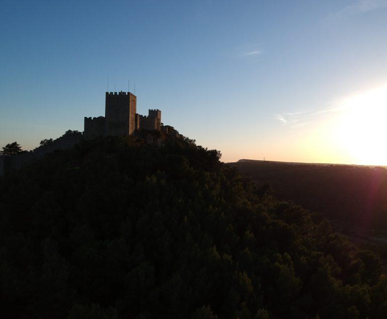 a castle sitting on top of a lush green hillside