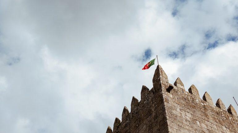 a stone building with flags on it