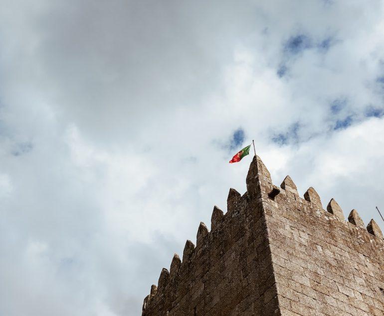 a stone building with flags on it