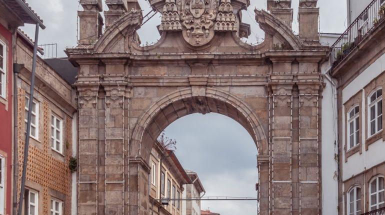 a large stone arch in the middle of a street