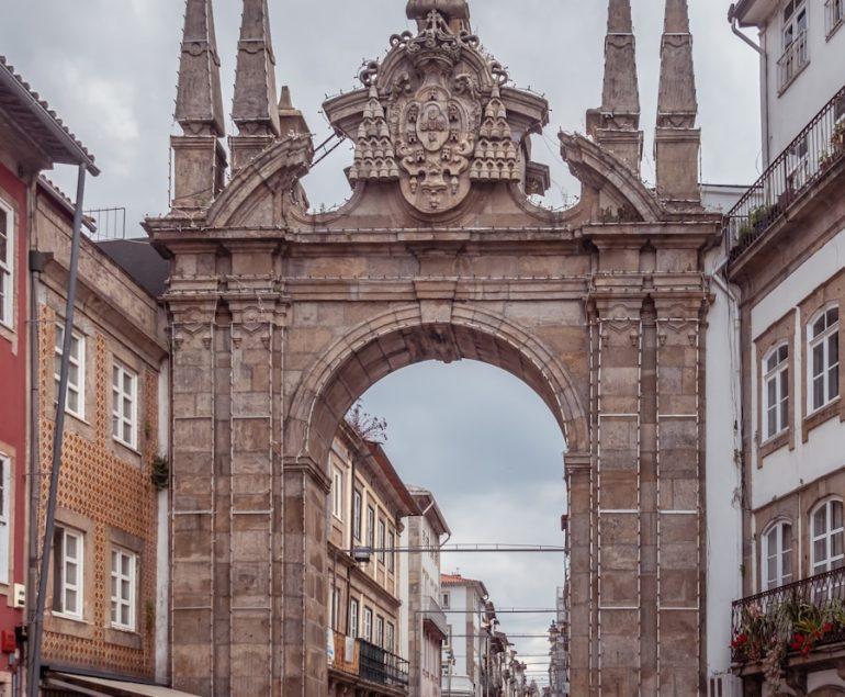 a large stone arch in the middle of a street
