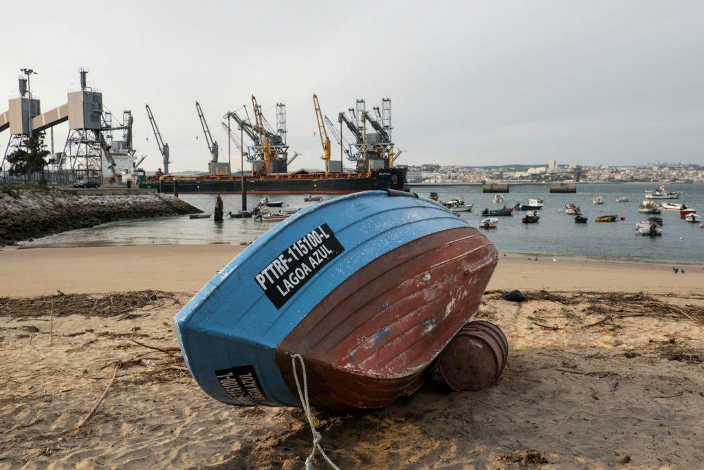 a boat sitting on top of a sandy beach