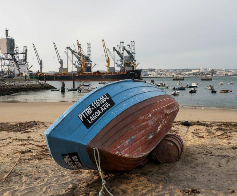 a boat sitting on top of a sandy beach