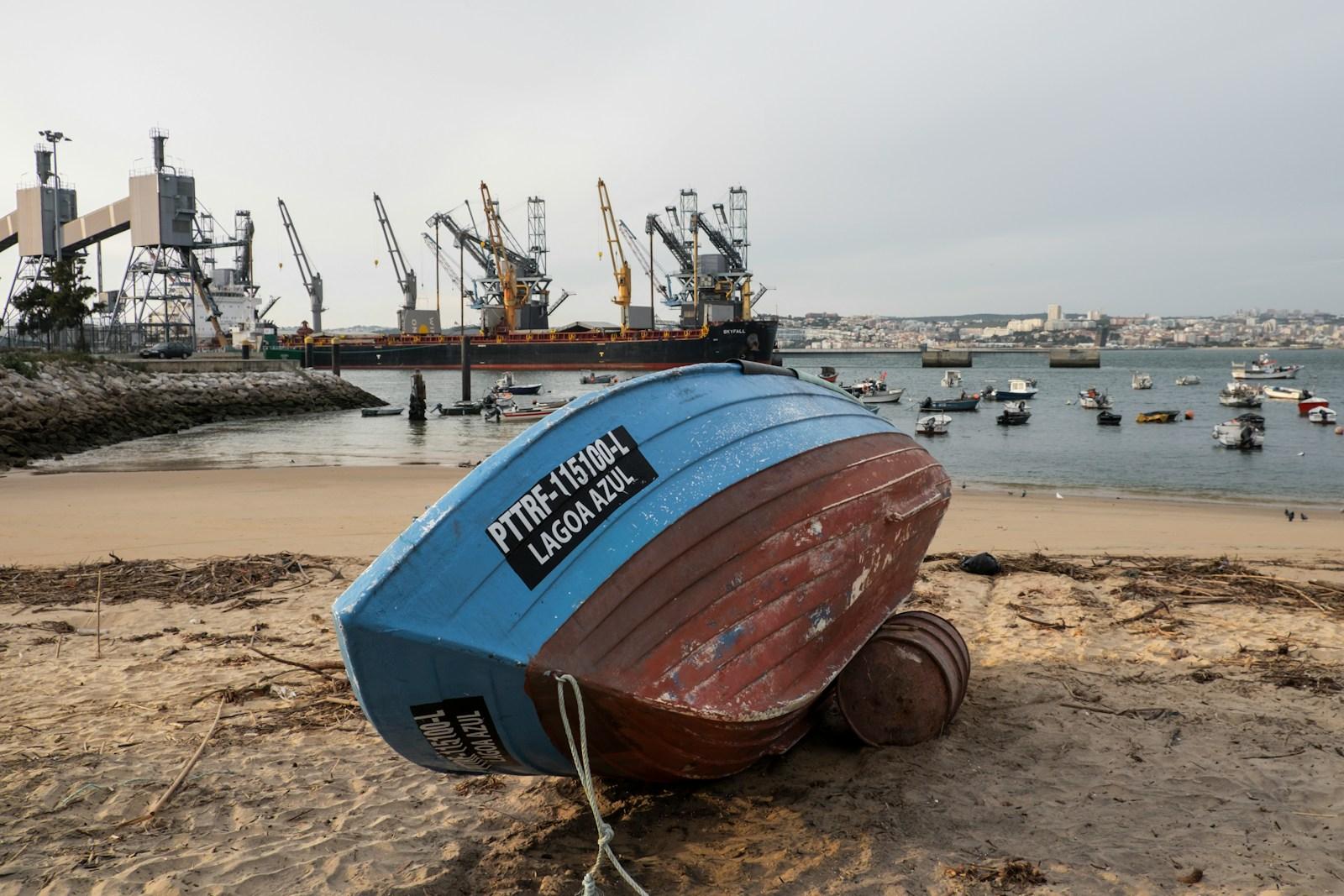 a boat sitting on top of a sandy beach